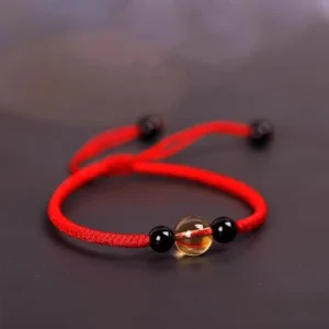 Red string bracelet with citrine and black obsidian beads three quarter side view
