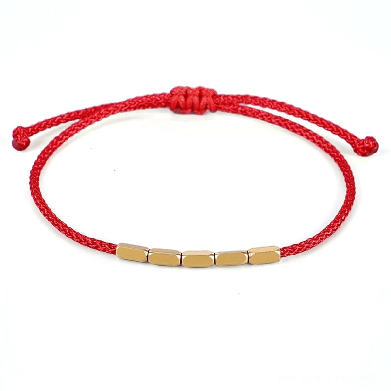 Red string copper bead bracelet with adjustable sliding knot, flat lay view