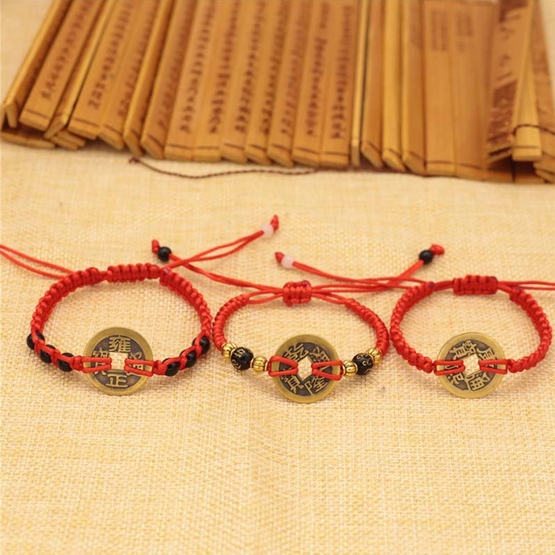 Adjustable red string braided bracelet with copper coin, minimalist design flat lay