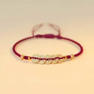 Burgundy red string copper coin fortune tree braided bracelet flat lay - handmade lucky bracelet