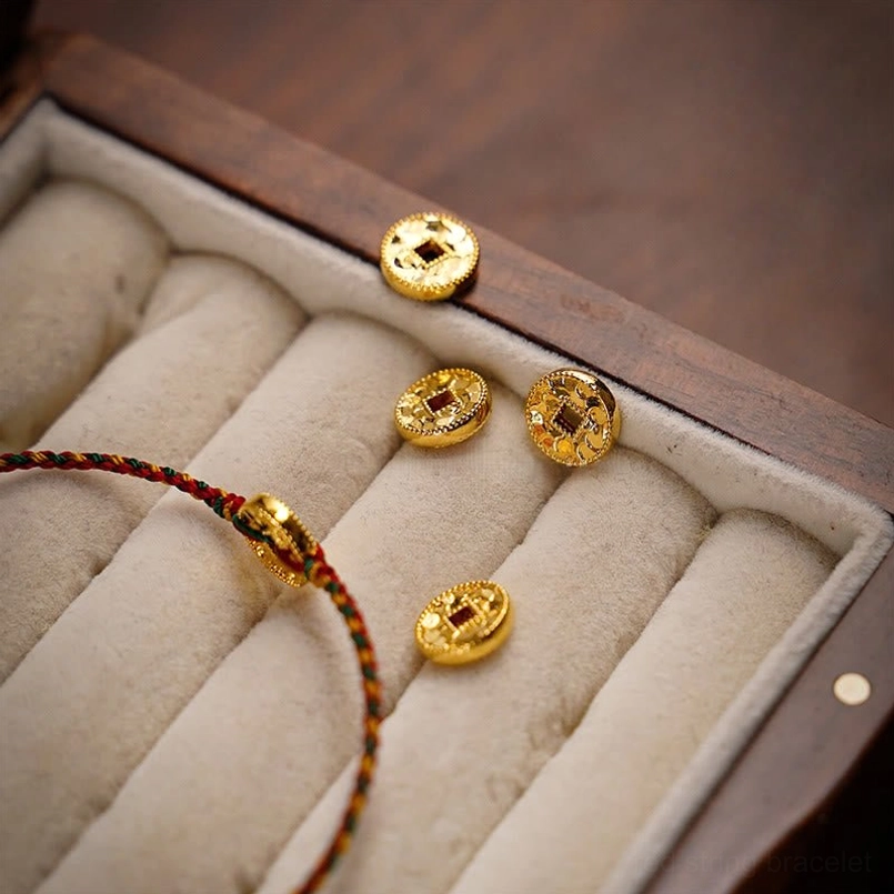 Red string copper coin jewelry set in velvet-lined box showing loose coins and sample bracelet