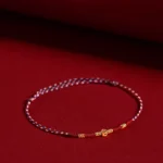 Red braided luck bracelet with copper coins and gold beads, side view showing detailed craftsmanship