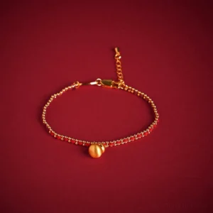 Red string copper brass gourd bracelet with adjustable tail chain and gold beads on dark background