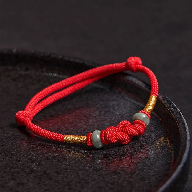 Red string couple bracelet with braided knot and jade bead detail