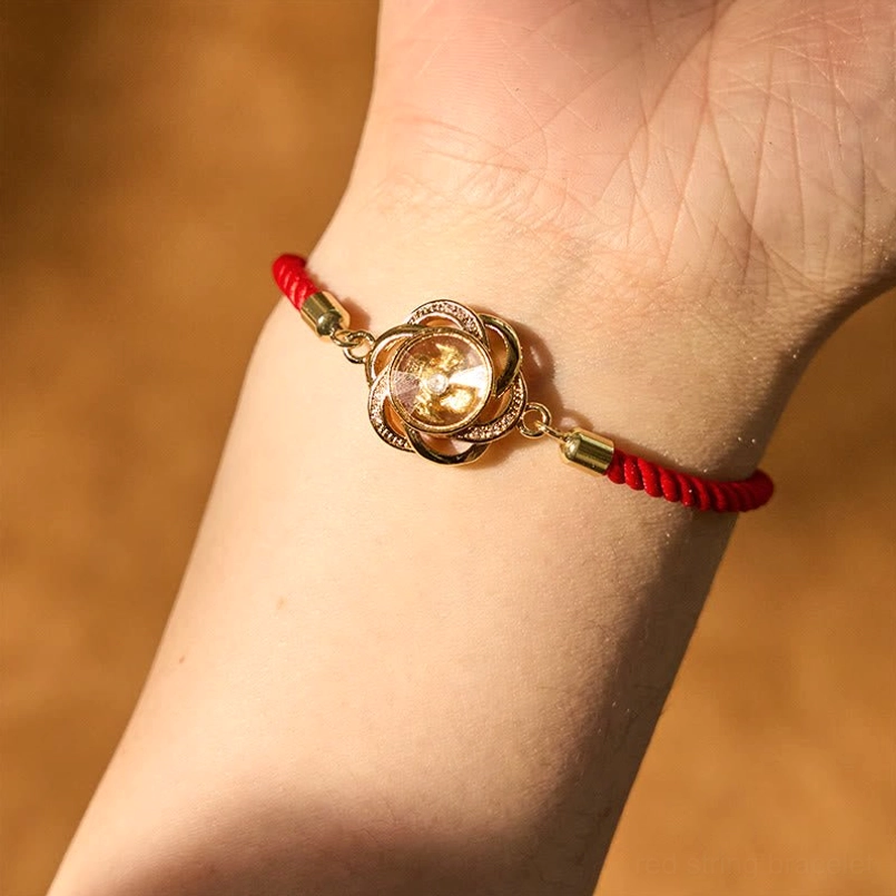 Rotatable plum windmill red string bracelet worn on human wrist side view