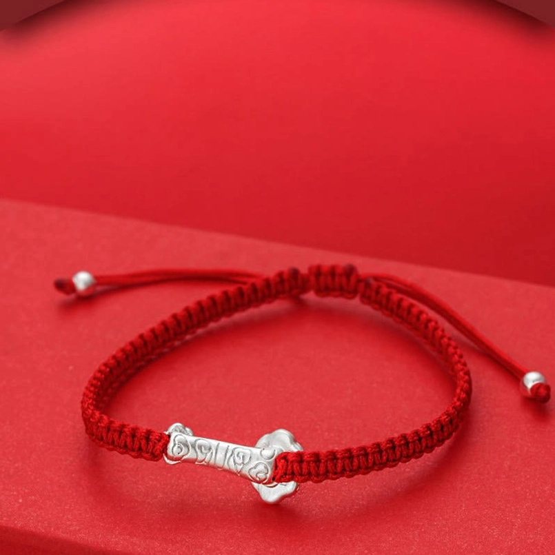 Low Angle Side View of Red String Fu Bracelet Featuring Silver Charm Underside and Sliding Knot Adjusters