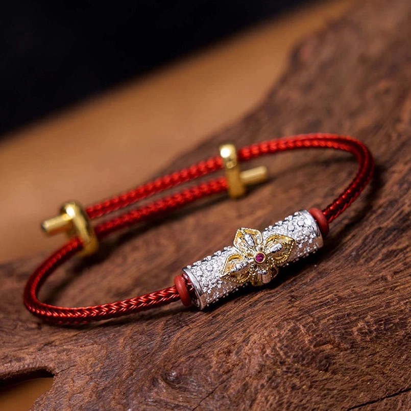 Red string protection bracelet with gold flower charm and colorful enamel petals
