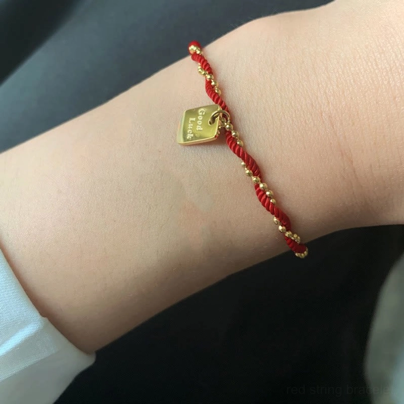 Unisex red string luck bracelet wearing shot on female wrist