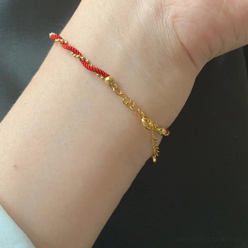Unisex red string luck bracelet wearing shot on male wrist