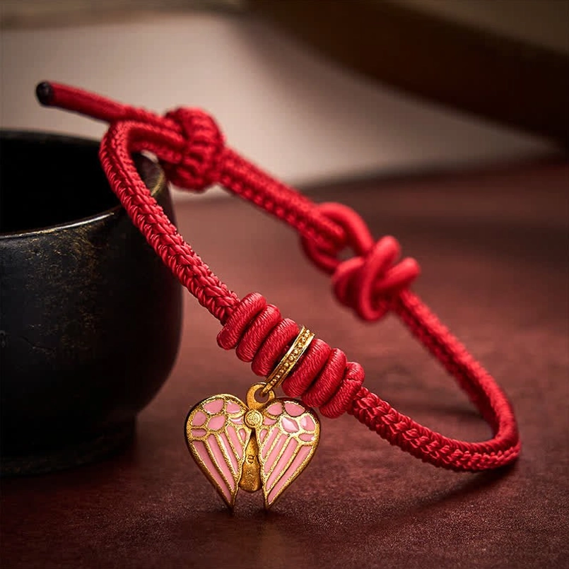 Red braided string bracelet with full open pink heart charm and adjustable pull knot