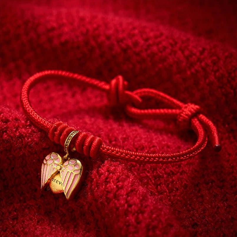 Handmade red string bracelet showing braided texture and heart charm detail