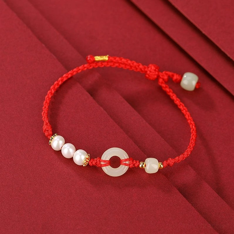 Single red string Hetian jade peace buckle bracelet top down view