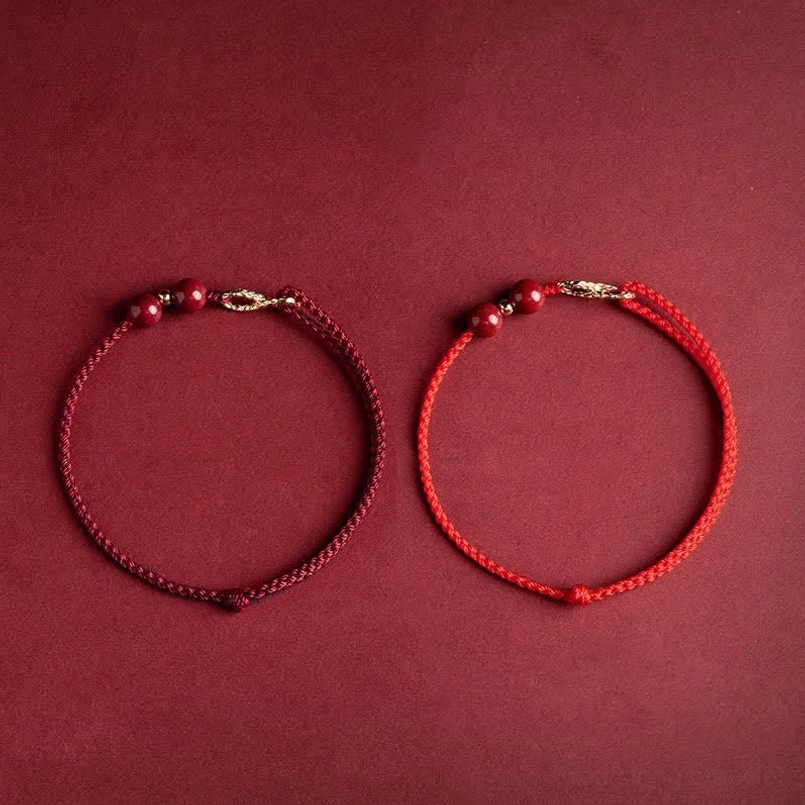 Red string infinity bracelet thickness and craftsmanship detail with cinnabar beads and gold accents