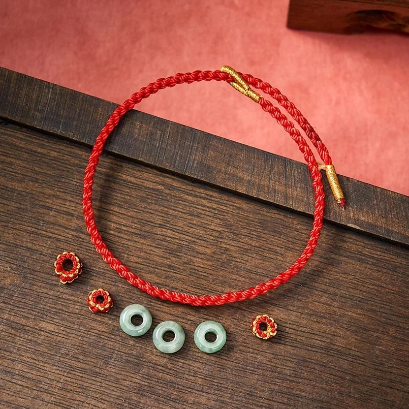 Red string jade bracelet showing adjustable knot closure for custom fit