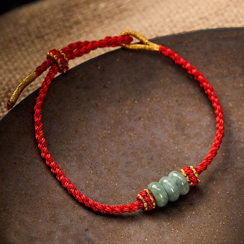 Red string jade bracelet showing intricate braided cord craftsmanship detail