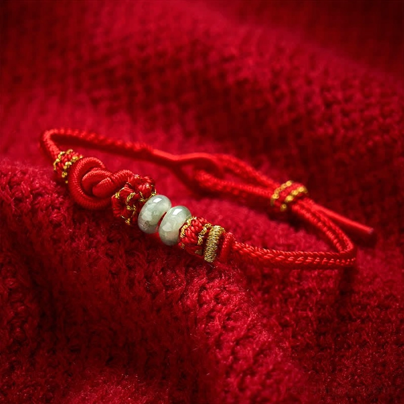 Red jade woven bracelet showing golden accents and cord texture