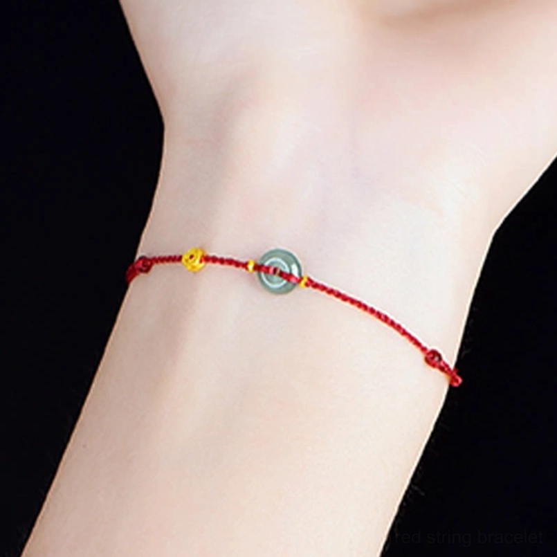 Red string bracelet with jade peace buckle and copper coin charm - product lifestyle flat lay photography