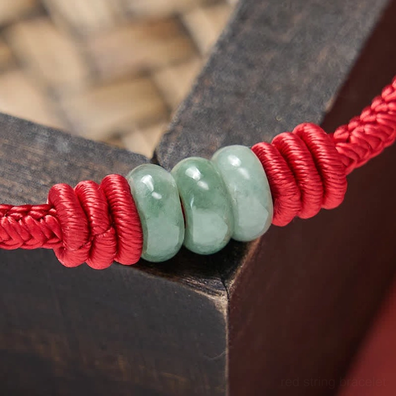 Handmade red string jade bracelet featuring natural green jade beads and protective red cord