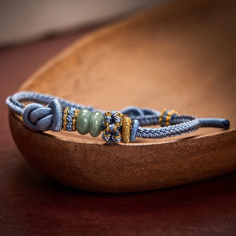 Red string jade bracelet showing natural jade variations and color