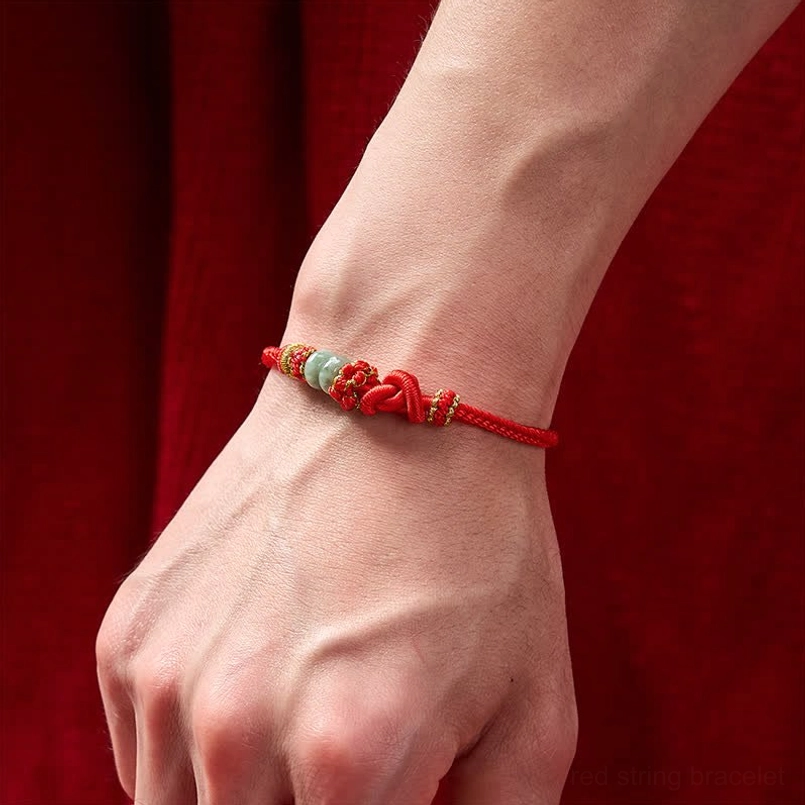 Red string jade bracelet worn on wrist showing proper fit and appearance