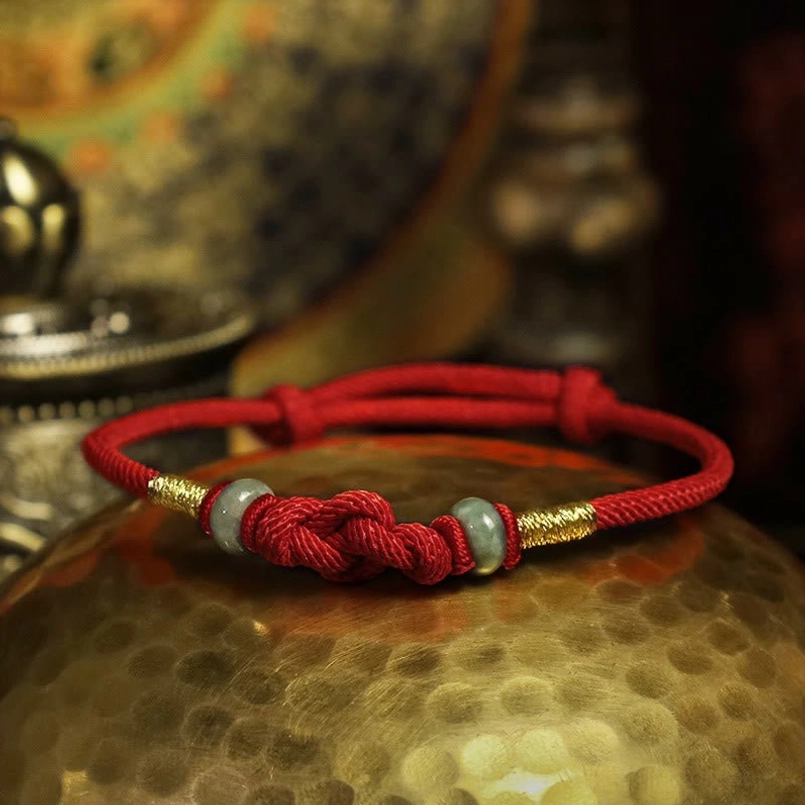 Side view of red string jade fortune bracelet showing knot and bead details
