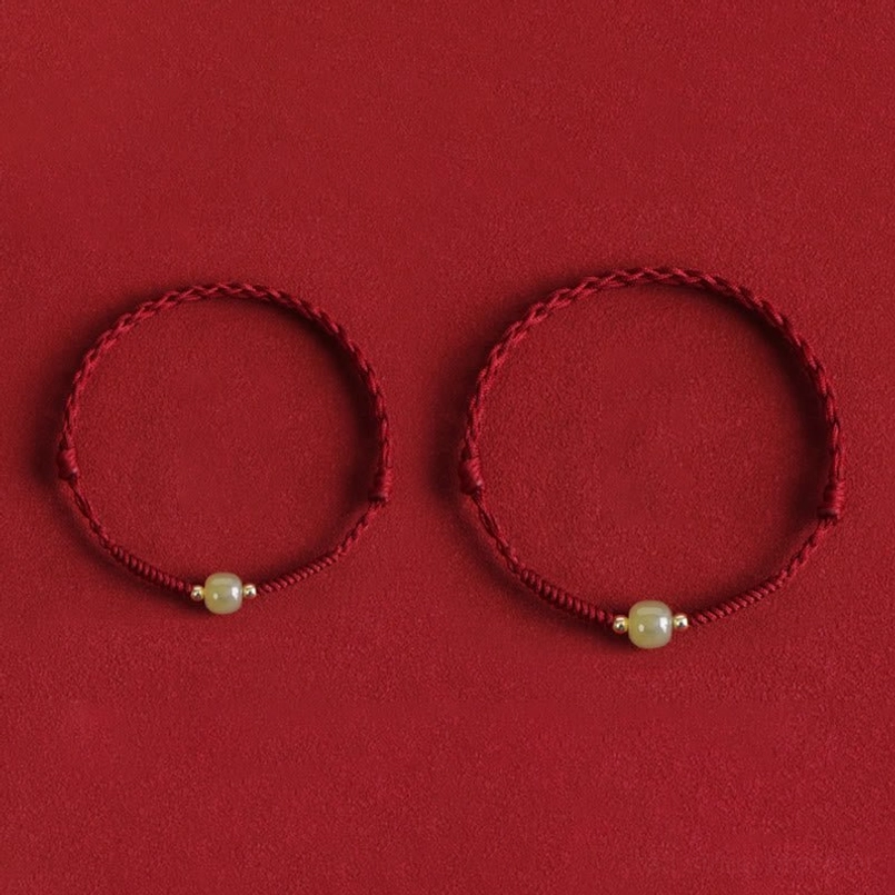 Two red string jade bracelets comparison front view red background