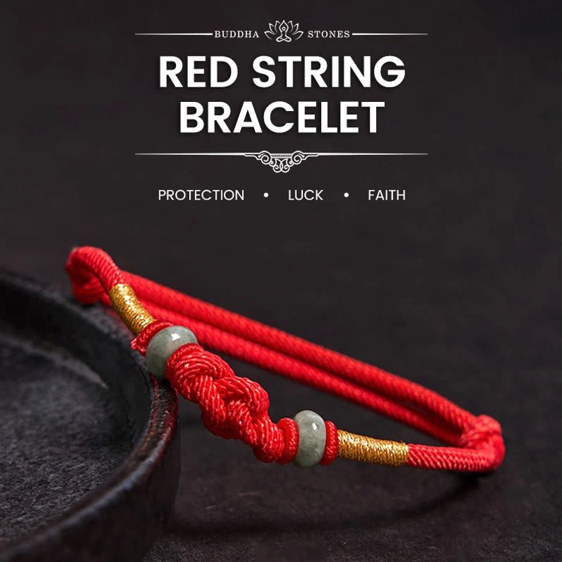 Red string jade fortune knot couple bracelet with gold accents on dark tray