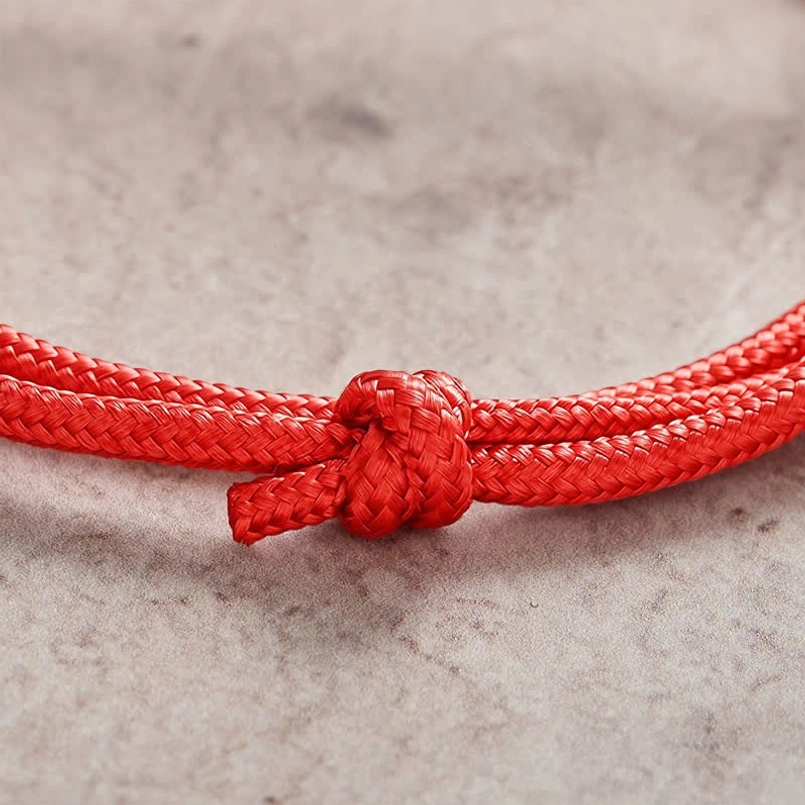 Double wrap braided rope knot detail close-up of red string whale bracelet