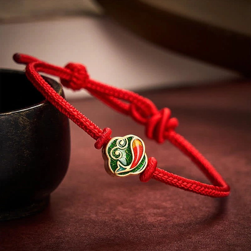 Red string koi fish bracelet with enamel charm and gold trim, adjustable sliding knot design