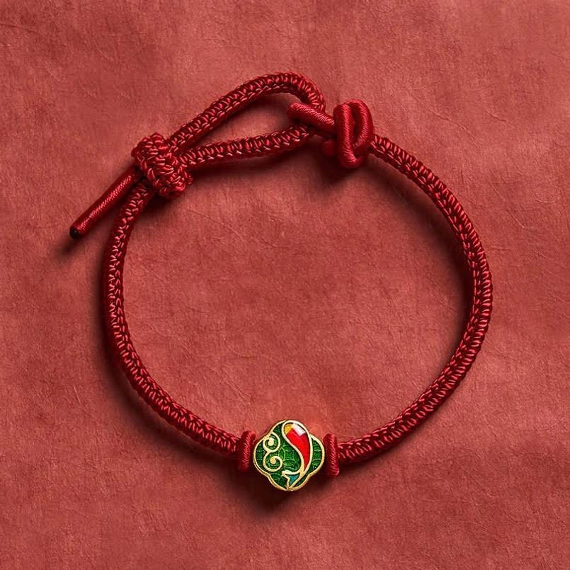 Red braided cord protection bracelet with enamel koi fish charm, overhead angle detail
