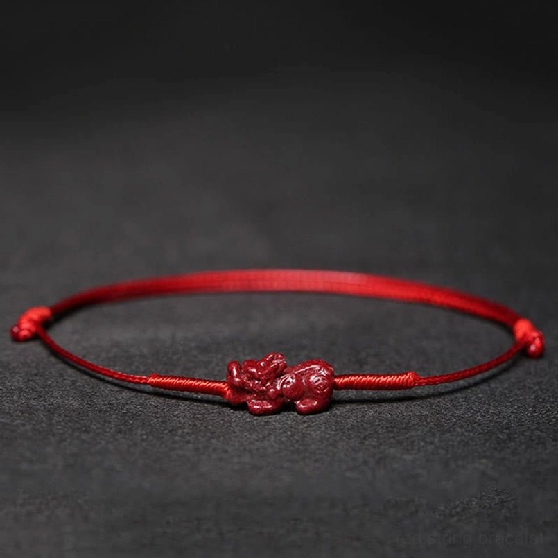 Red cord bracelet with koi fish charm flat lay photography