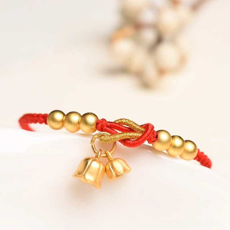 Handcrafted red woven bracelet with twisted knot and matte gold lily charm