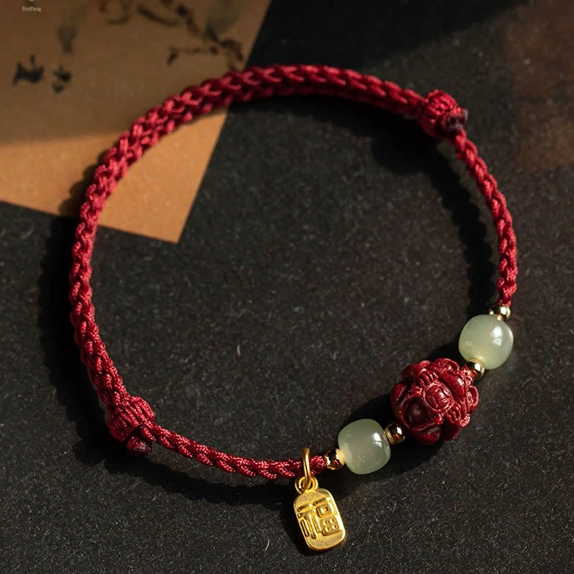 Red string luck bracelet with fu character pendant - close-up of sterling silver charm