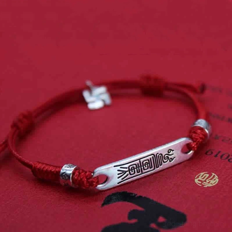 Red string luck bracelet featuring swastika charm and silver decorative beads, prosperity symbol