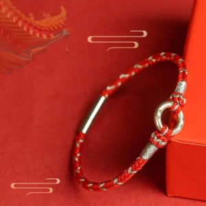 Red string luck bracelet with 925 sterling silver peace buckle on red festive background with gift box