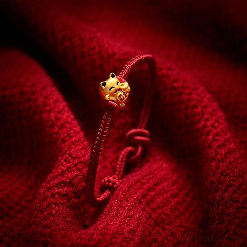Mini golden lucky cat charm on thin braided red string bracelet with adjustable pull knot