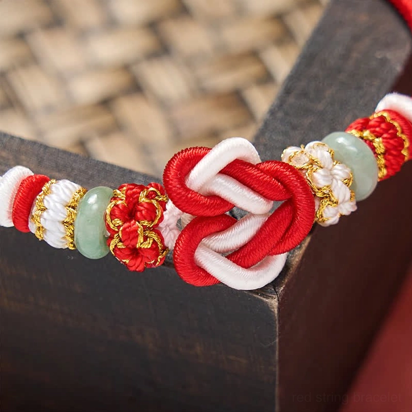 Red string lucky knot bracelet with genuine jade and woven cord details