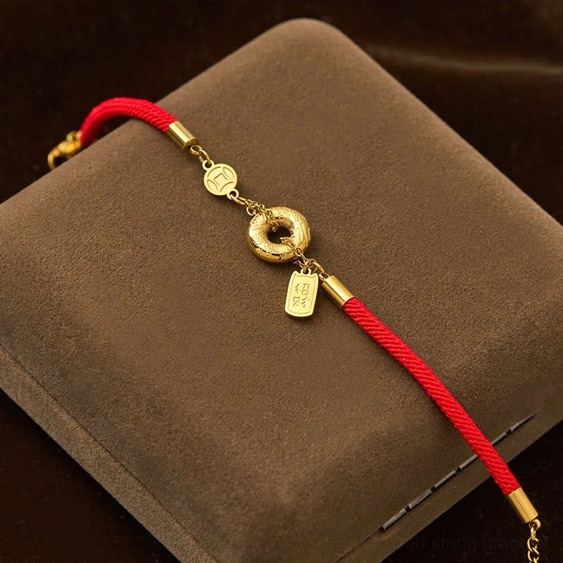 Braided red cord peace buckle bracelet with gold metal decorative charms in storage box