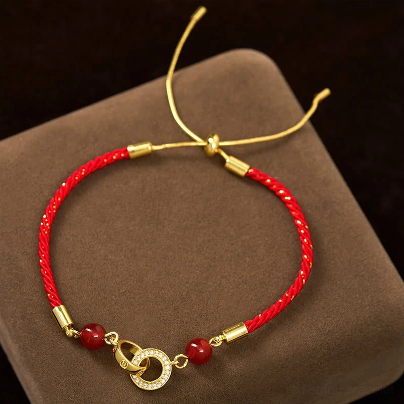 Rear high angle view of red string peace buckle bracelet showing adjustable pull cord