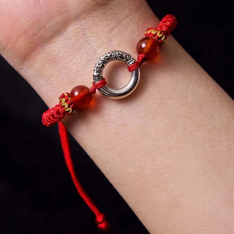 Red peace buckle bracelet worn on wrist showing proper fit and comfort