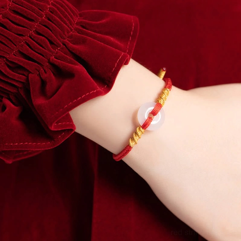 Red string peace buckle bracelet worn on wrist with gold twisted knots and chalcedony pendant, wrist view