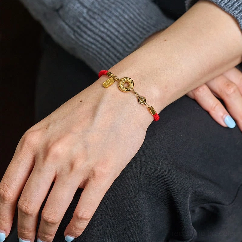 Red string peace buckle bracelet worn on woman's wrist in everyday casual lifestyle setting