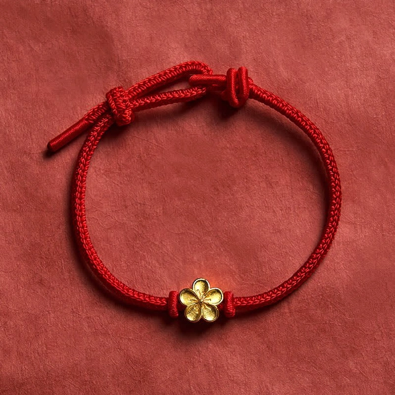 Adjustable red string luck bracelet with gold peach blossom charm flat display