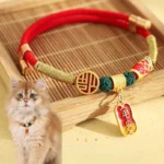 Red braided string pet collar with gold Fu blessing charm on bamboo tray
