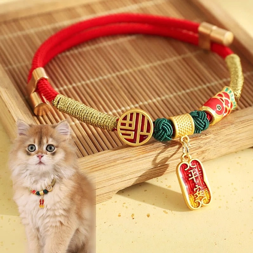 Red braided string pet collar with gold Fu blessing charm on bamboo tray