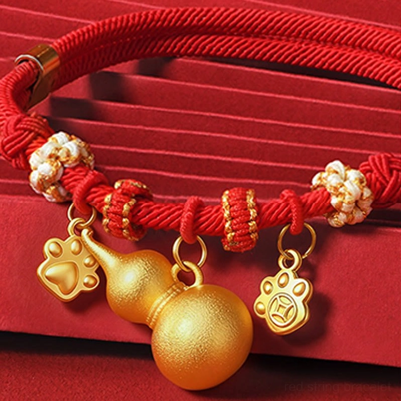 Close-up red rope pet collar with gold gourd paw and coin shaped prosperity pendants