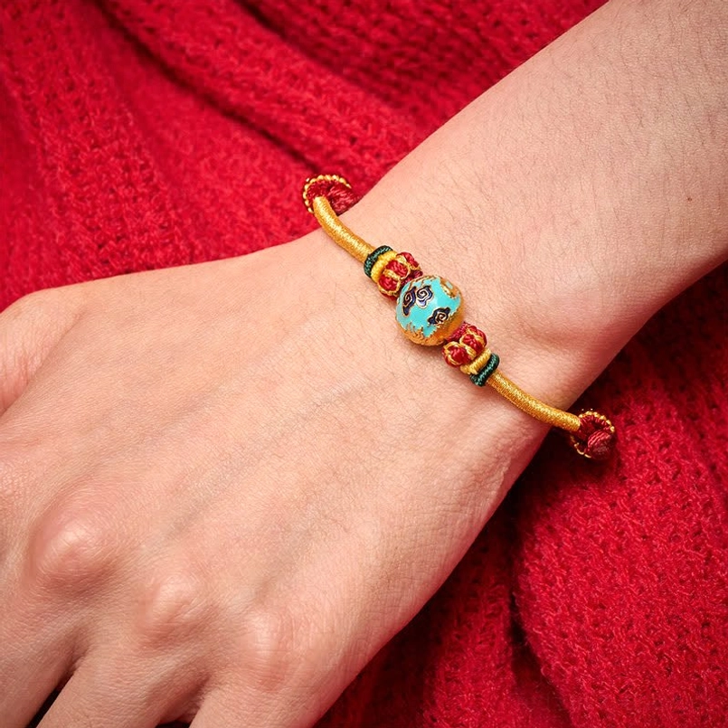 Phoenix bead variant on red string bracelet with protective energy symbolism
