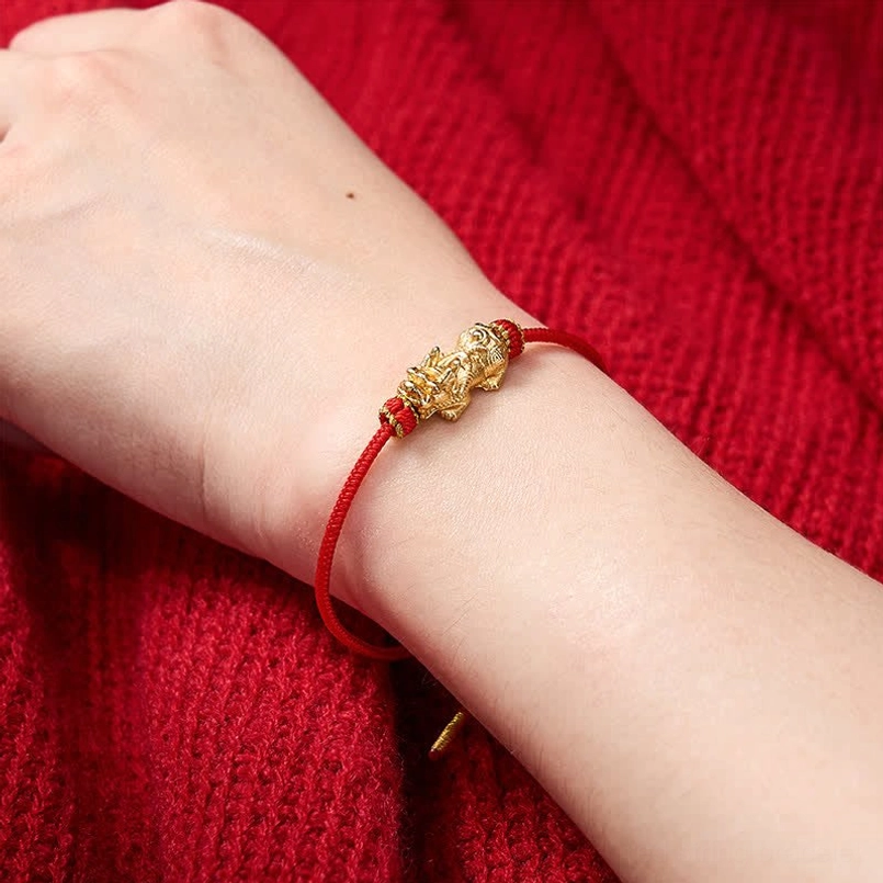 Red string Pixiu bracelet worn on wrist with Pixiu ornament visible - lifestyle wearing shot