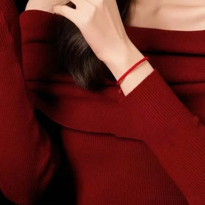 minimal red string five god of wealth bracelet worn on wrist with red sweater