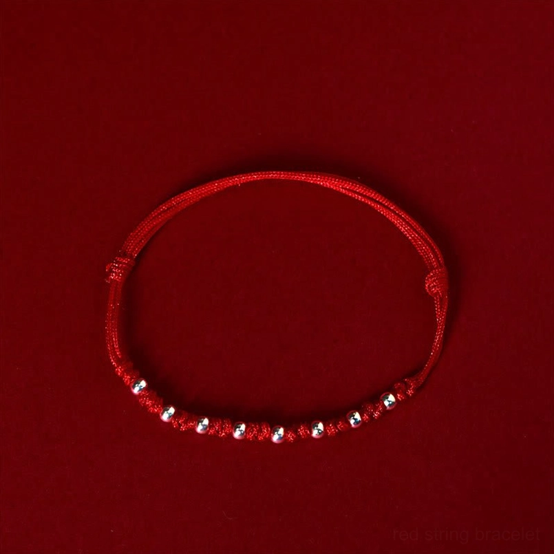 Front flat view of handmade red string luck bracelet with silver beads and protective knots